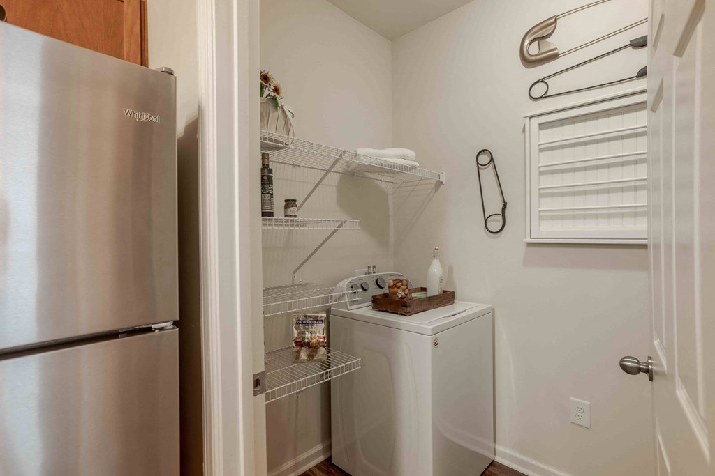 a small laundry room with a refrigerator and a washer and dryer