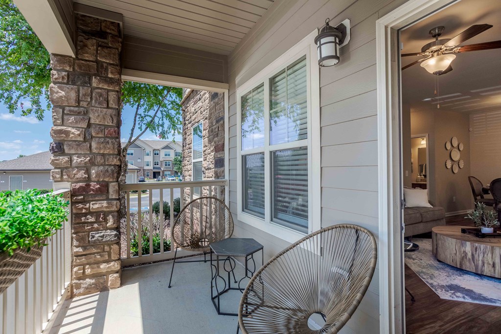 a porch with two chairs and a table on it