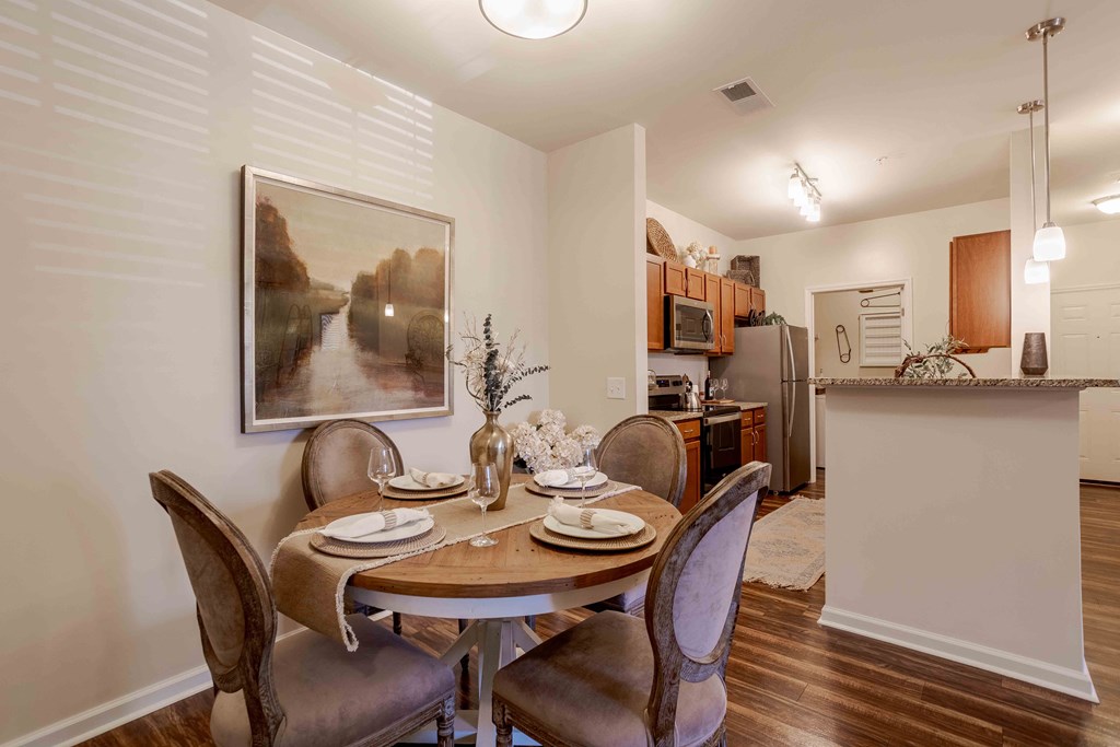 a dining room table with chairs next to a kitchen