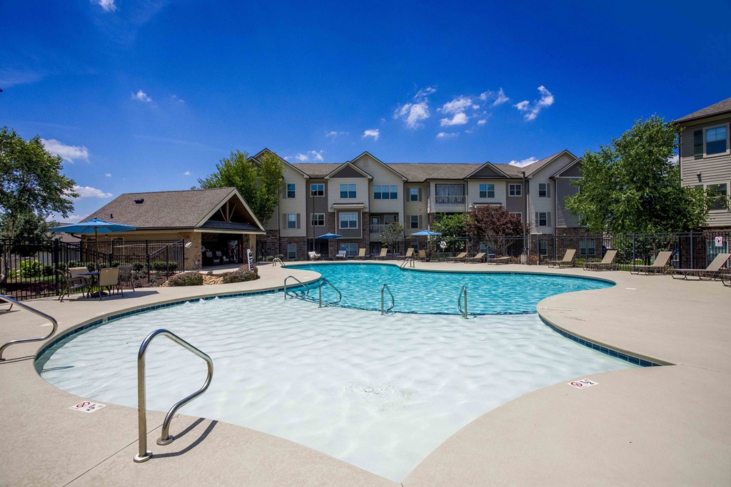a swimming pool with an apartment building in the background