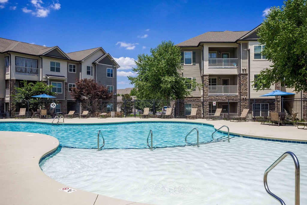 a swimming pool with an apartment building in the background