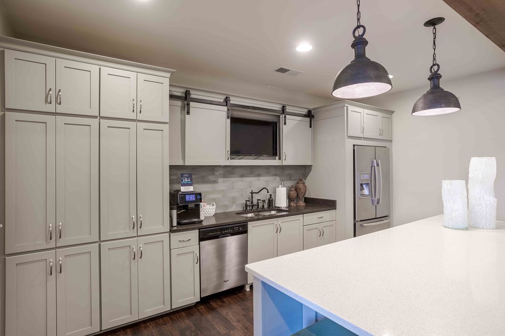 a white kitchen with stainless steel appliances and white cabinets