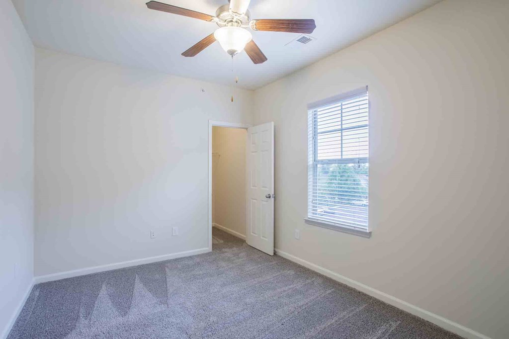 Bedroom with carpeted floors, a window and a ceiling fan