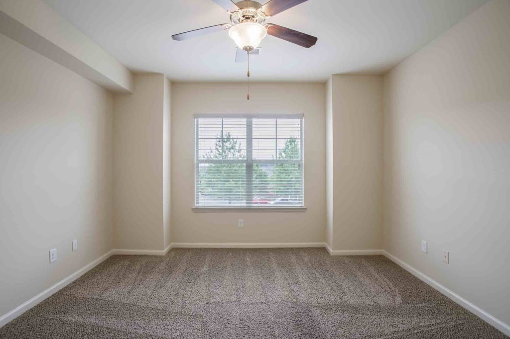 Bedroom with carpeted floors, a window, and a ceiling fan