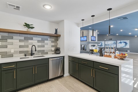A kitchen with green cabinets and a white countertop.