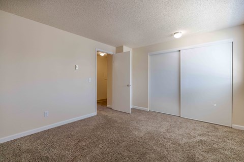 A room with a carpeted floor and a white door.