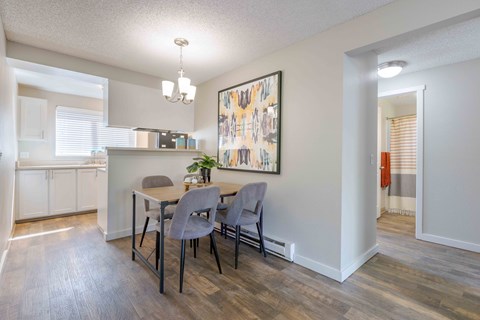 A dining room with a table and chairs.