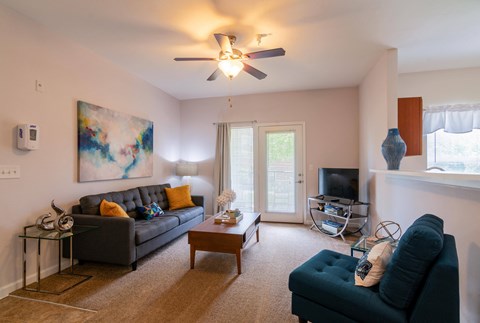 a living room with a ceiling fan and a couch