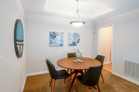 a dining room with a wooden table and chairs