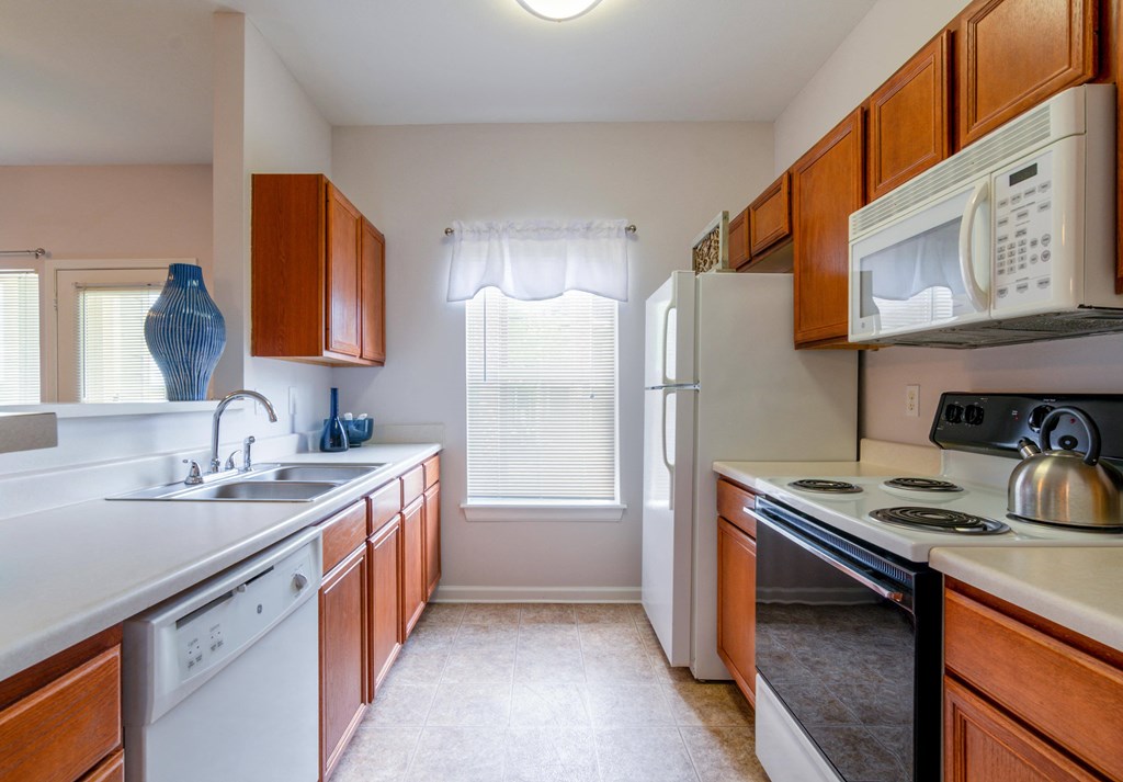 a kitchen with white appliances and wooden cabinets