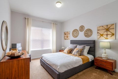 a bedroom with a bed and a dresser and a window