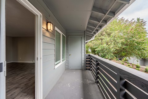 a long porch with a white door and a balcony