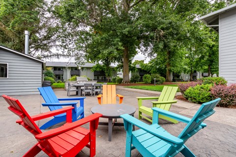 a group of colorful chairs around a table in a courtyard