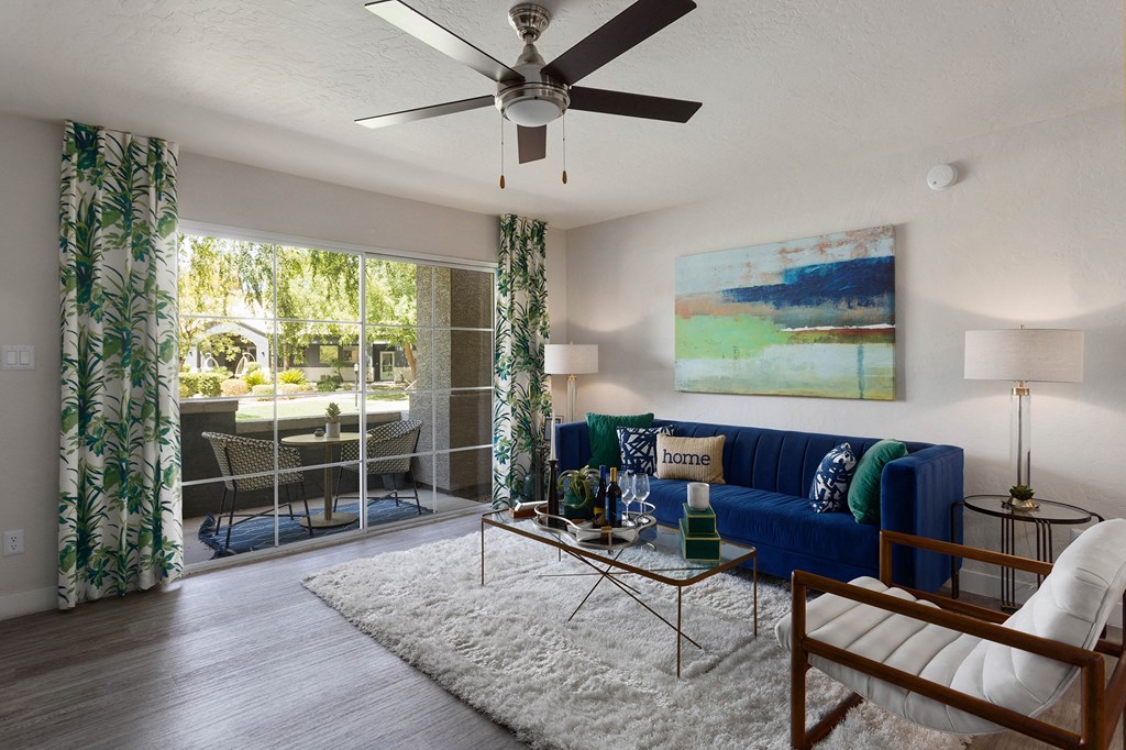 a living room with a blue couch and a ceiling fan