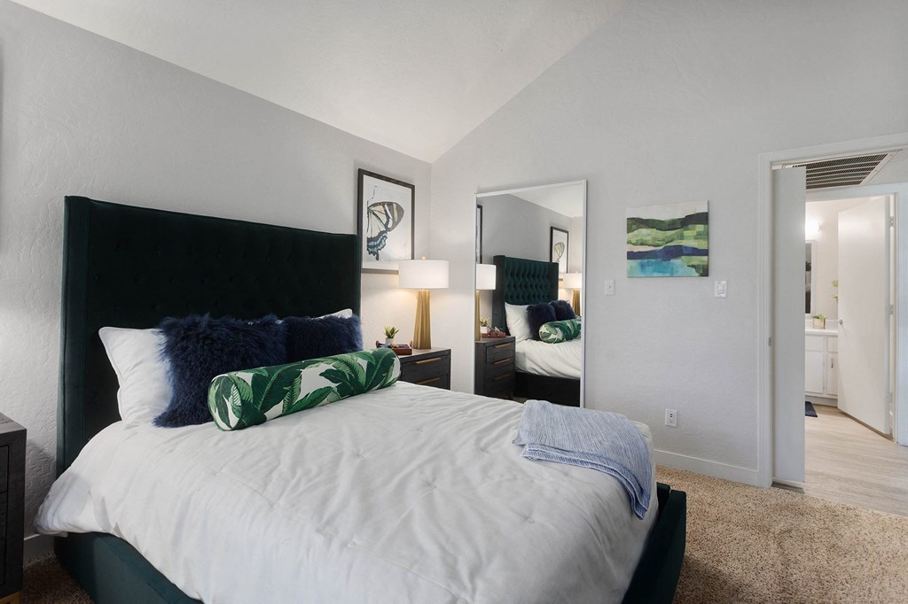 a bedroom with a large bed and a mirror