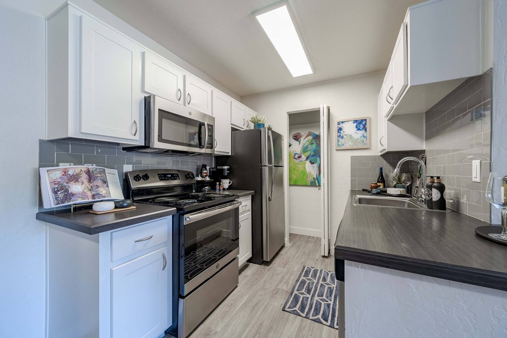 a kitchen with stainless steel appliances and white cabinets