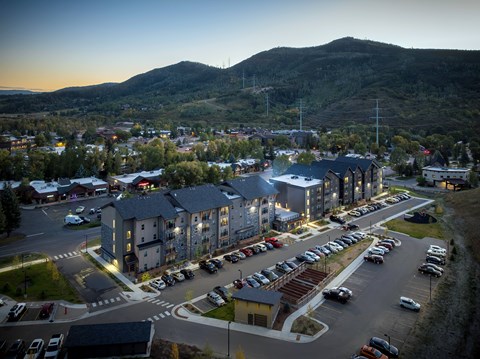 A parking lot with cars and apartment buildings in the background.