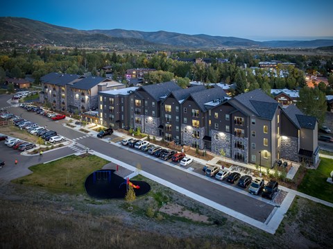 A large building complex with a parking lot in front of it.
