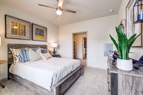 A bedroom with a large bed and a ceiling fan.