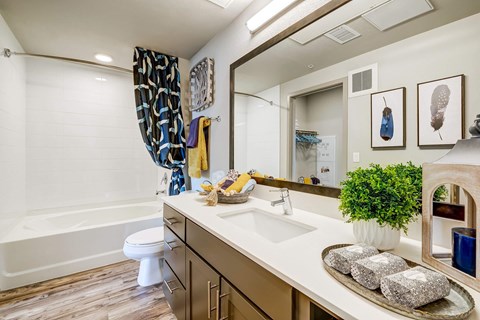A bathroom with a white counter top and a white toilet.