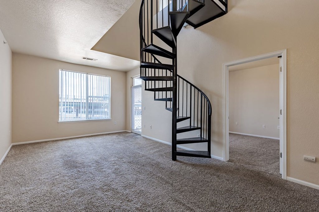 an empty living room with a spiral staircase
