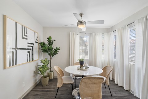 A dining room with a white table and chairs.