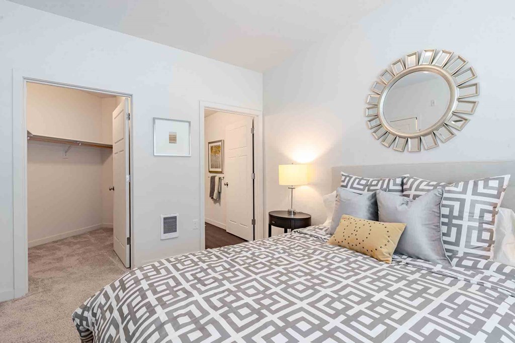 A bedroom with a large bed and a walk-in closet.