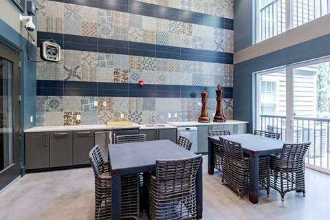 a dining room with tables and chairs and a kitchen with a window