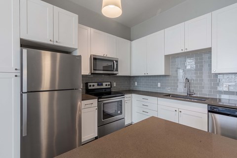 a kitchen with stainless steel appliances and white cabinets