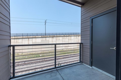 a balcony with a view of a train track and a door