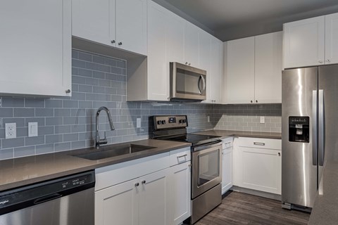 a kitchen with stainless steel appliances and white cabinets