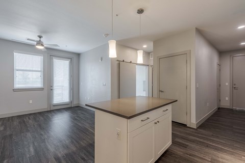 the living room and kitchen in a new home with white walls and wood flooring