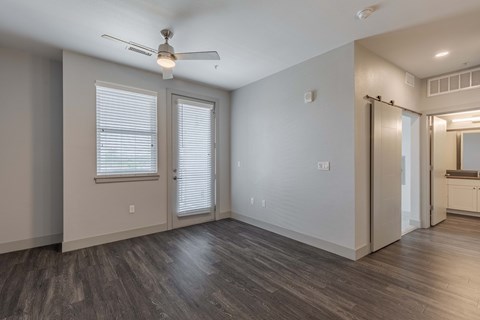 the living room of an empty house with a ceiling fan
