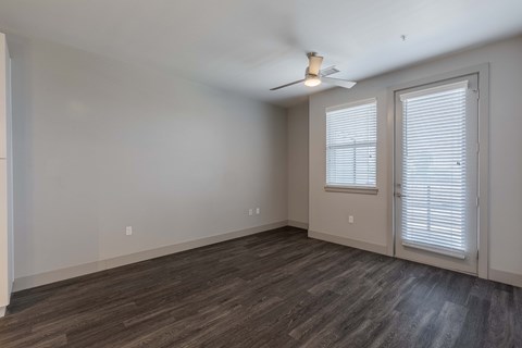 an empty living room with white walls and a ceiling fan