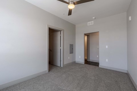 an empty living room with white walls and a ceiling fan