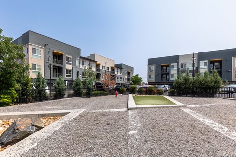 an empty parking lot in front of a row of apartment buildings