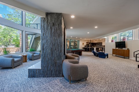 A large room with a stone pillar and grey carpet.
