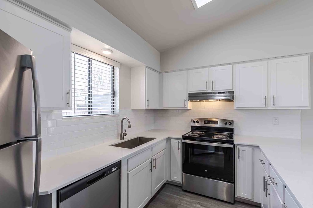 A kitchen with white cabinets and stainless steel appliances.