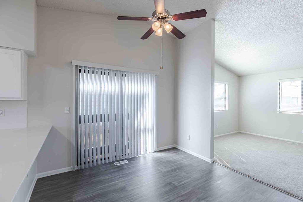 Dining room with ceiling fan and door to private balcony