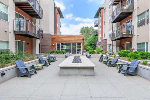 A courtyard with a bench and a building in the background.