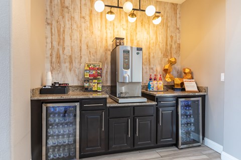A kitchen area with a refrigerator, oven, and a counter with a few items on it.