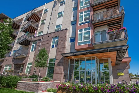A modern apartment building with balconies and flower boxes.