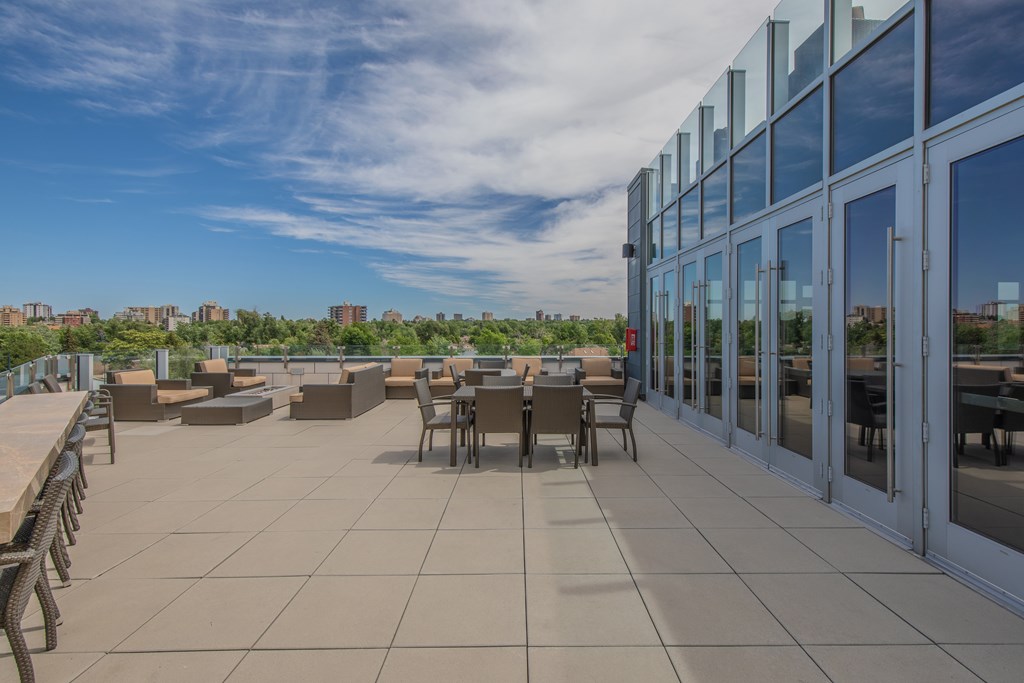 A rooftop patio with a table set for dining.