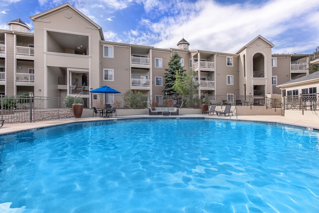 A large swimming pool in front of apartment buildings.