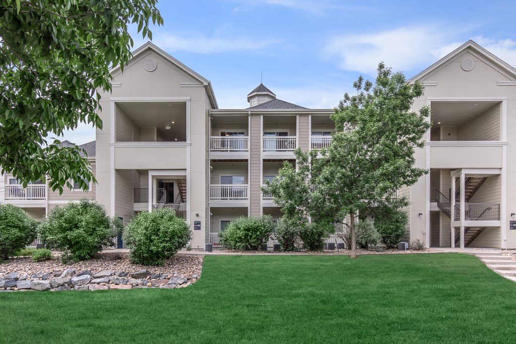 Apartment complex with a green lawn in front.