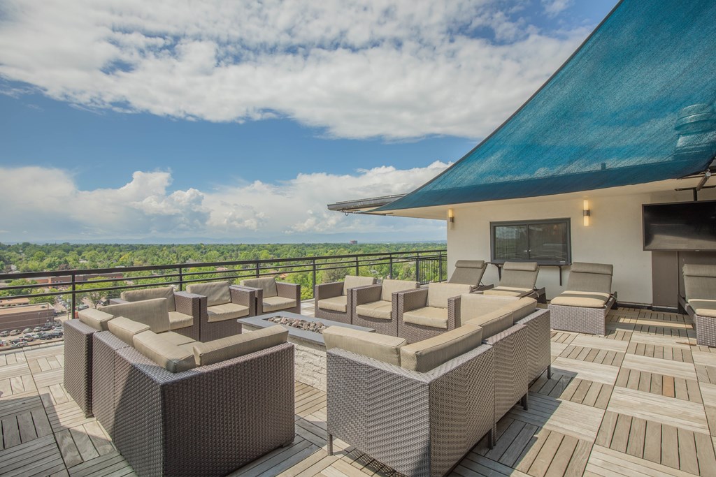 Two couches on a patio with a blue roof and a view of the sky.