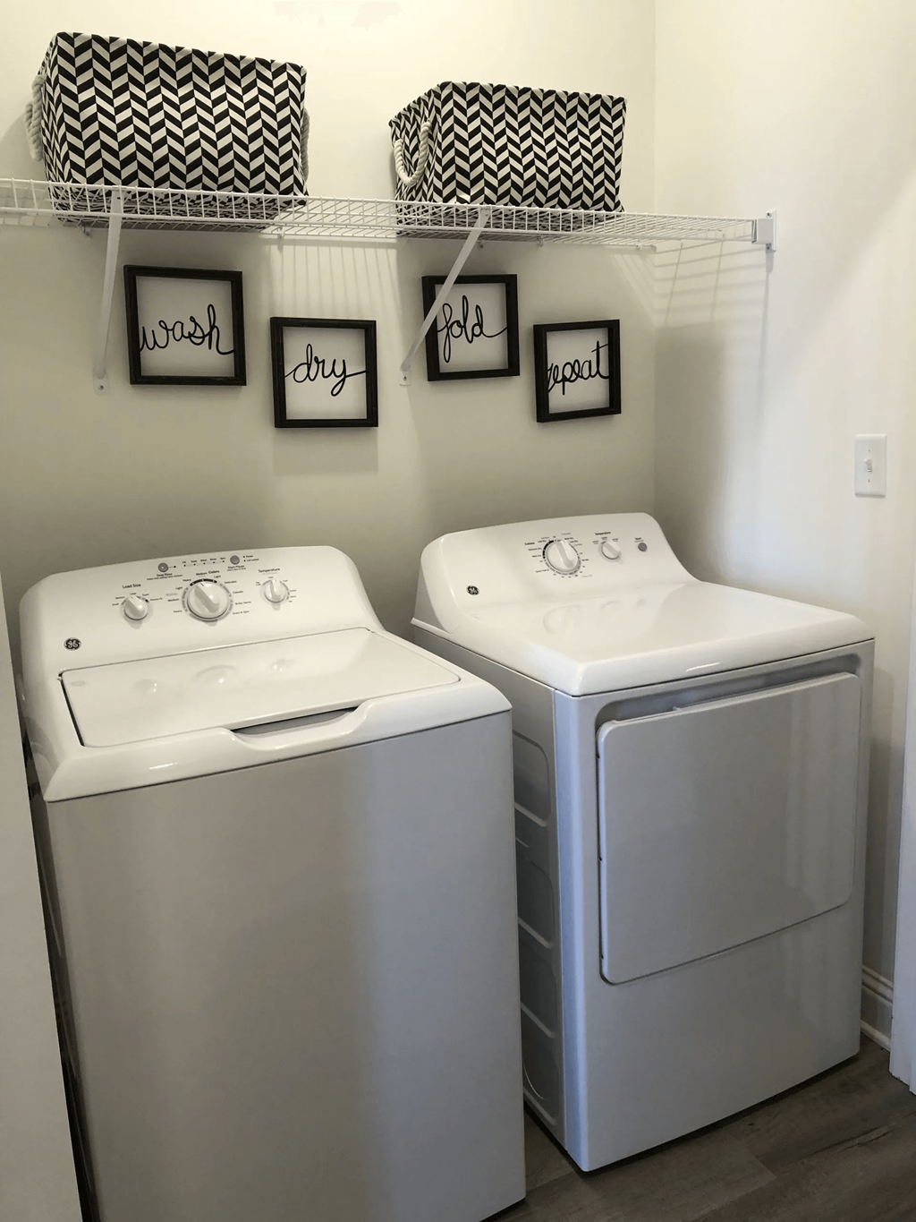 Two front load washing machines in a laundry room.