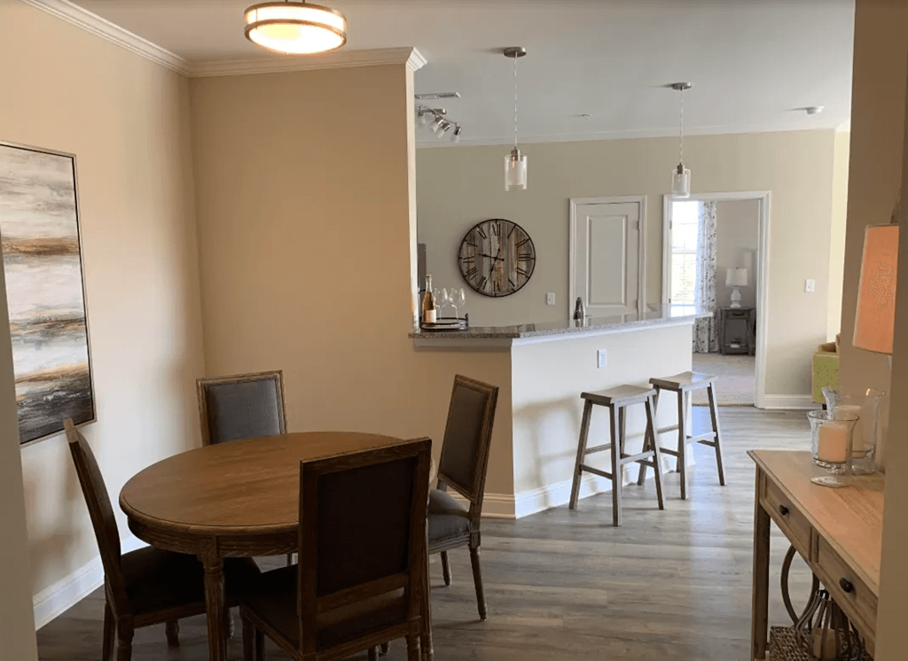 A dining room with a wooden table and chairs.