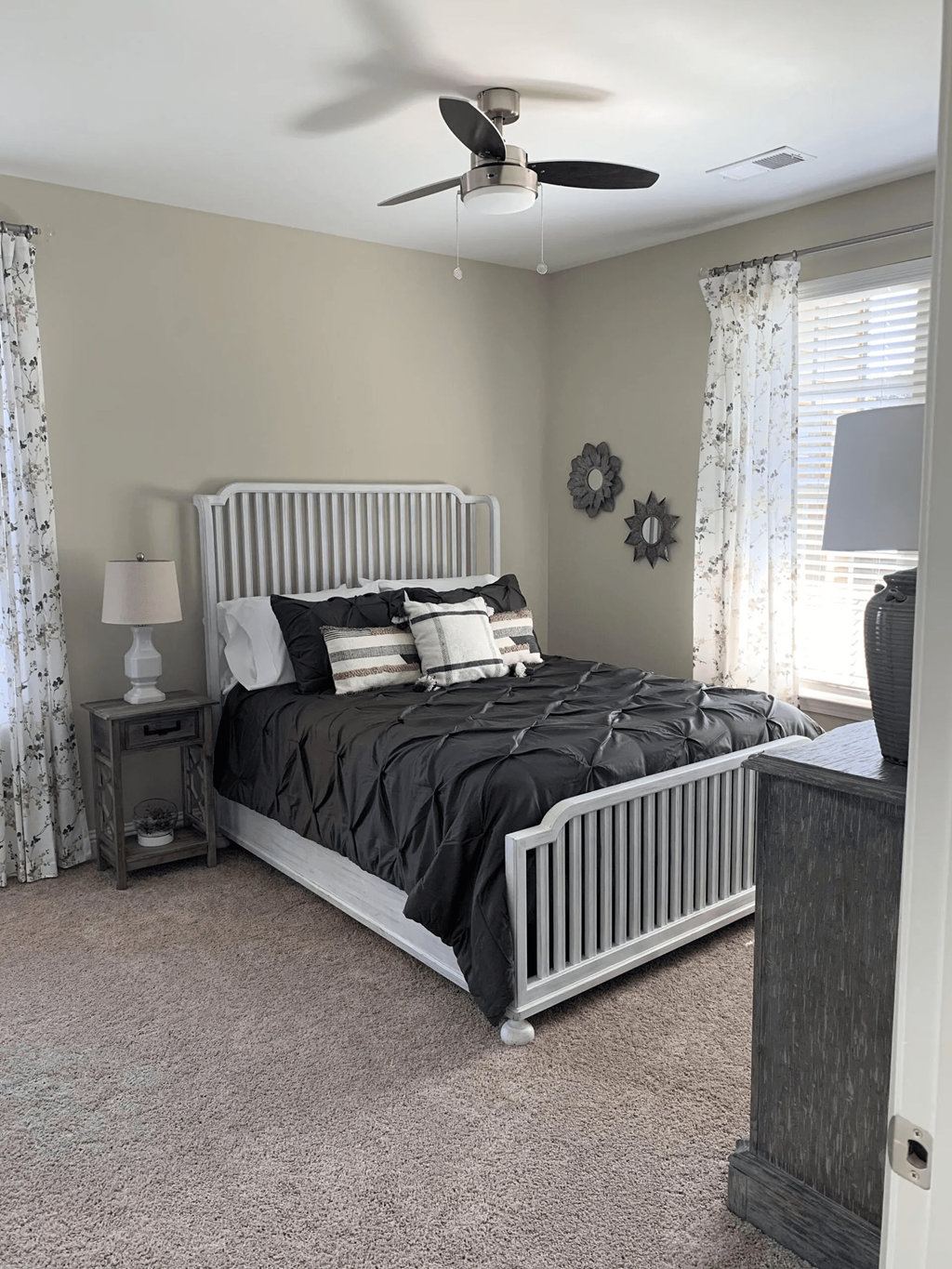 A bedroom with a large bed and a ceiling fan.