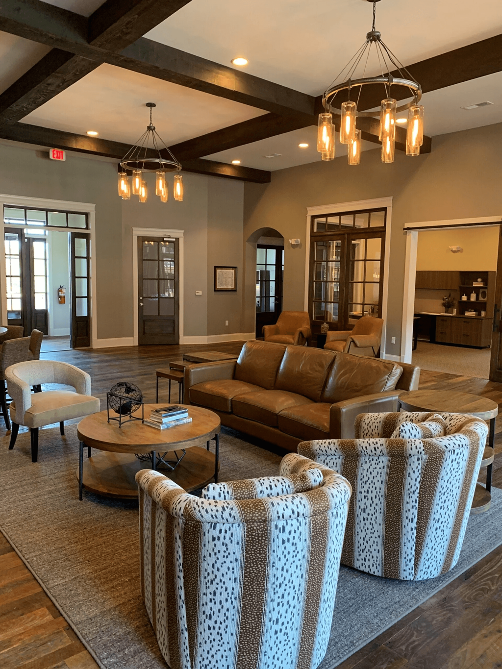 Clubhouse  with a brown couch, a coffee table, and a chandelier.